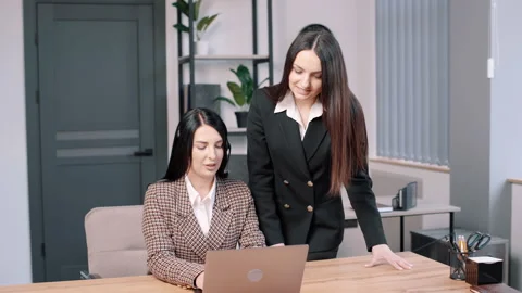 Two girl in a tech support office, female is talking on a headset with customer Stock-Footage 237333896