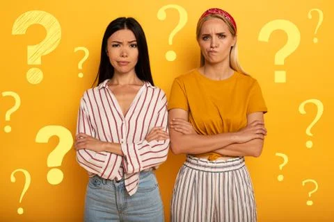 Two girl with troubled expression are diffident about something. Yellow Stock Photos