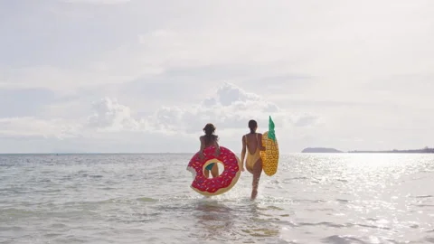 Two girlfriends are walking with their dog along the seashore with brightly Stock Footage 245451022