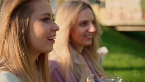 Two girlfriends drinking red champagne in park outdoors Stock Footage 194295191