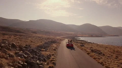 Two girlfriends driving on a red cabriolet. Best friends spend summer time Stock Footage 181171982