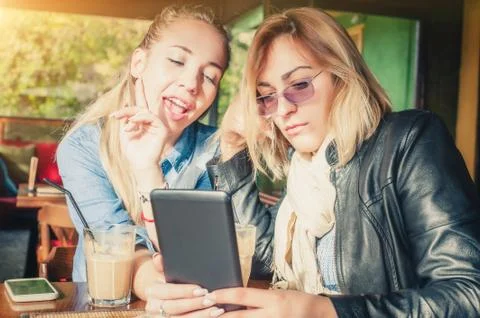 Two girlfriends having fun with digital tablet Stock Photos