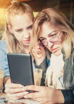 Two girlfriends having fun with digital tablet Stock Photos