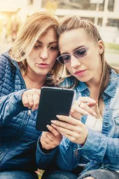 Two girlfriends having fun with digital tablet Stock Photos