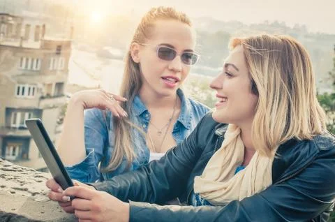 Two girlfriends having fun with digital tablet Stock Photos