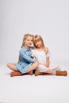 Two girlfriends or sisters with the same hair color are hugging. Stock Photos