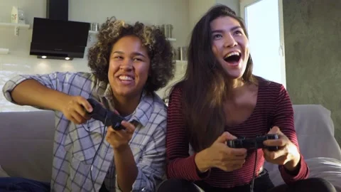 Two girlfriends play with joysticks Stock Footage 164746955