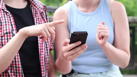 Two girlfriends viewing content on smartphone Video stock 337624350