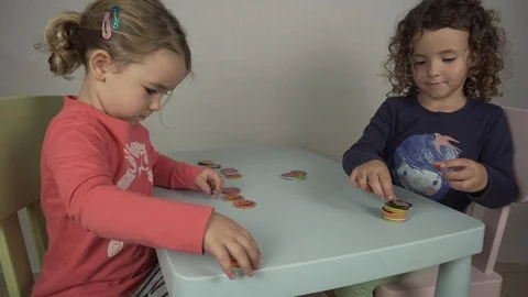 Two girls of 5 and 3 years old play with chocolate hallowen coins Stock-Footage 97237553
