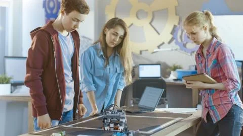 Two Girls and a Boy Program Self Driving Robot for School Science Class Proje 库存照片