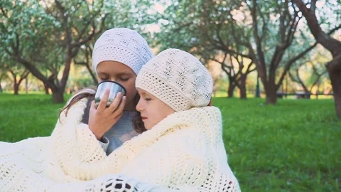 Two girls are drinking tea in the park. Are heated. Close-up. 스톡 동영상 90376542