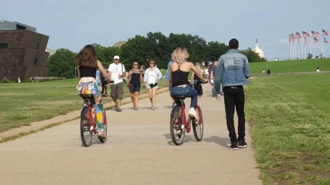 Two Girls on Bikes Riding Towards Washington Monument in DC, 4K Stock Footage