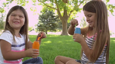 Two girls blowing bubbles Video stock 67349386