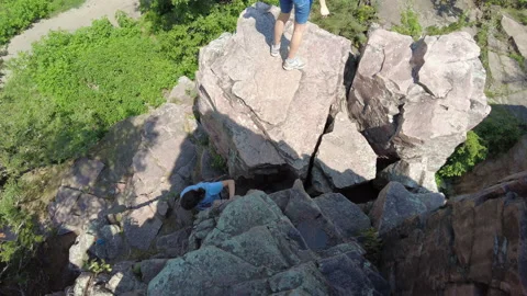 Two girls climbing down cliffs in South Dakota Stock Footage 161827711