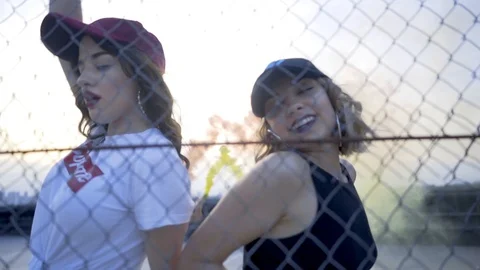 Two girls dance behind the grid Stock Footage 91724482