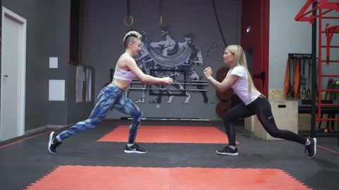 Two girls doing a lunge exercise during a workout training in slow motion. Stock Footage 141261408