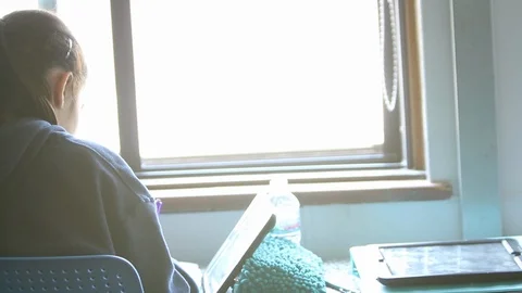 Two girls doing school work near a window in school Stock Footage 92265607