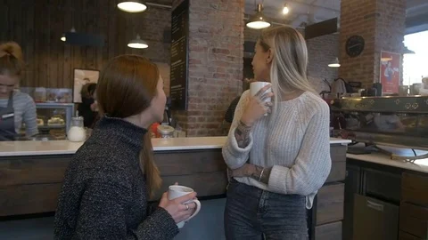 Two girls drinking coffee in a cafe Stock Footage 71167910