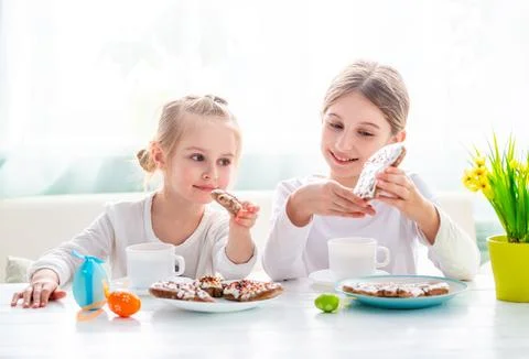 Two Girls Drinking Tea With Easter Cookies Stock Photos