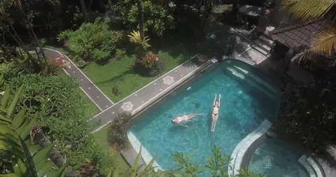 Two Girls Floating in Pool Drone Shot Stock Footage 106238471