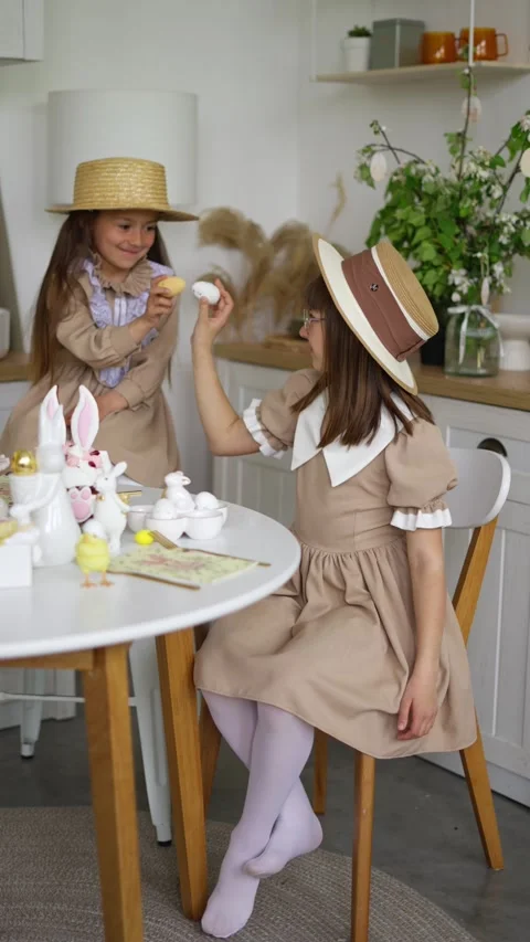 Two girls in hats play with Easter eggs. Concept of Easter and traditions. Stock Footage 277984189