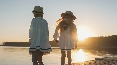 Two girls having fun jumping in the beautiful white dress on background of sea s Stock Footage 93553310