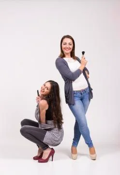 Two girls having fun in studio, white background Stock Photos