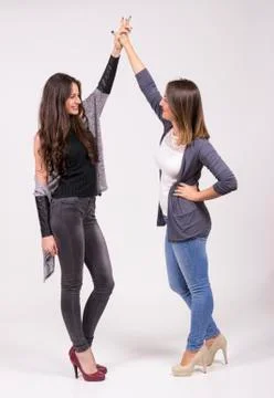 Two girls having fun in studio, white background Stock Photos