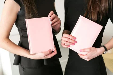 Two girls hold business notebooks in hand Stock Photos