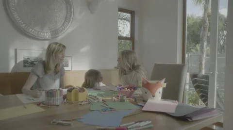 Two girls laugh with mom while doing art then run out to play Stock Footage 68355026