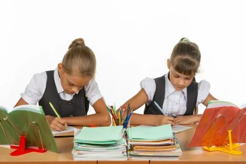 Two girls in a lesson write in a notebook Stock Photos