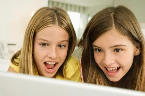 Two girls looking at a laptop with surprise Stock Photos