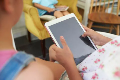 Two girls looking at a  tablet computer, close up,crop Stock Photos