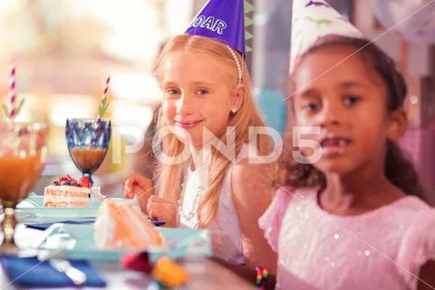 Two girls looking at you while being at birthday party Stock Photos