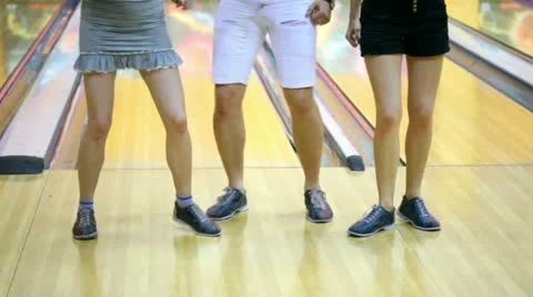 Two girls with one guy dance in bowling club Stockbeeldmateriaal 11045424