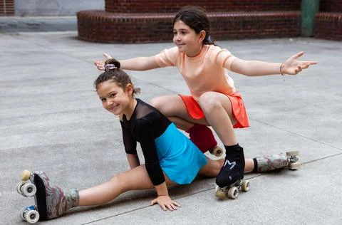 Two Girls Performing Flexibility Pose While Roller Skating Foto stock