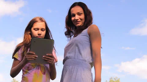 Two girls play work with a tablet, iPad, the laptop Stock Footage 25327161