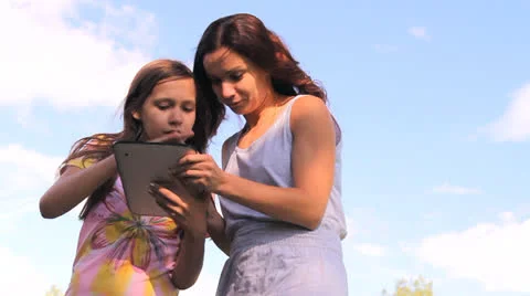 Two girls play work with a tablet, iPad, the laptop Stock Footage 25327925