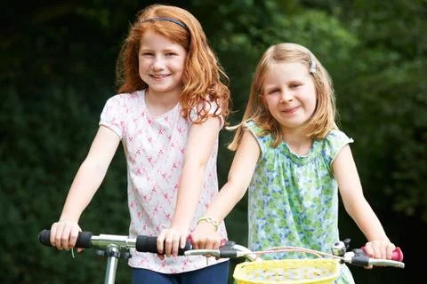 Two Girls Playing On Bike And Scooter Outdoors Stock Photos