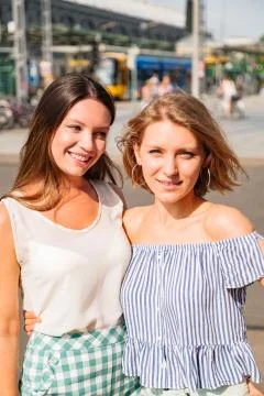 Two girls posing for camera hugging each other Stock Photos