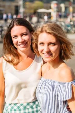 Two girls posing for camera hugging each other Stock Photos