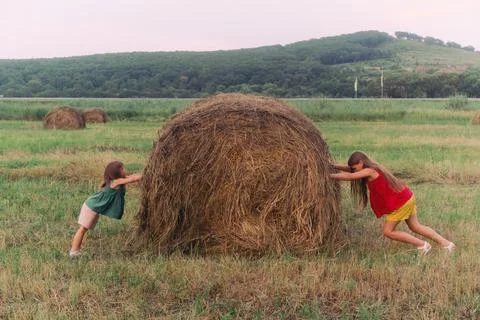 Two girls pushing a haystack Foto stock