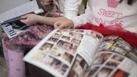Two Girls Reading Through A Glossy Magazine Fashion Clothing Catalog Video stock 69218593