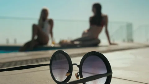 Two girls relax by the pool Stock Footage 139830862