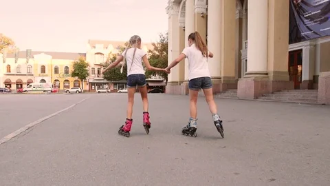 Two girls rollerblading in the town square Vídeos de archivo 79407217