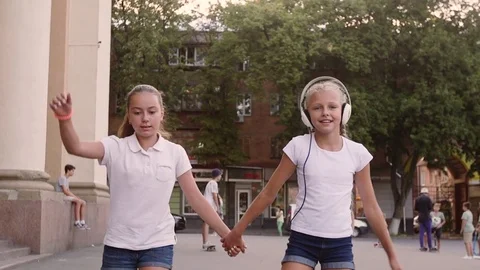 Two girls rollerblading in the town square Stock Footage 79407845