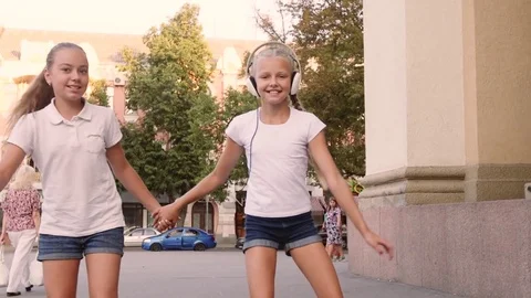 Two girls rollerblading in the town square Video stock 79407920