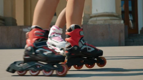 Two girls rollerblading in the town square Stock Footage 115507046