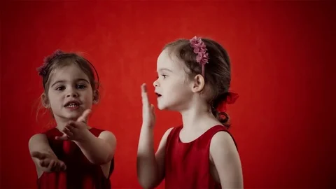 Two girls send a kiss on a red background Stock Footage
