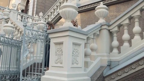 Two girls sit down the Gothic stairs Stock Footage 104480606